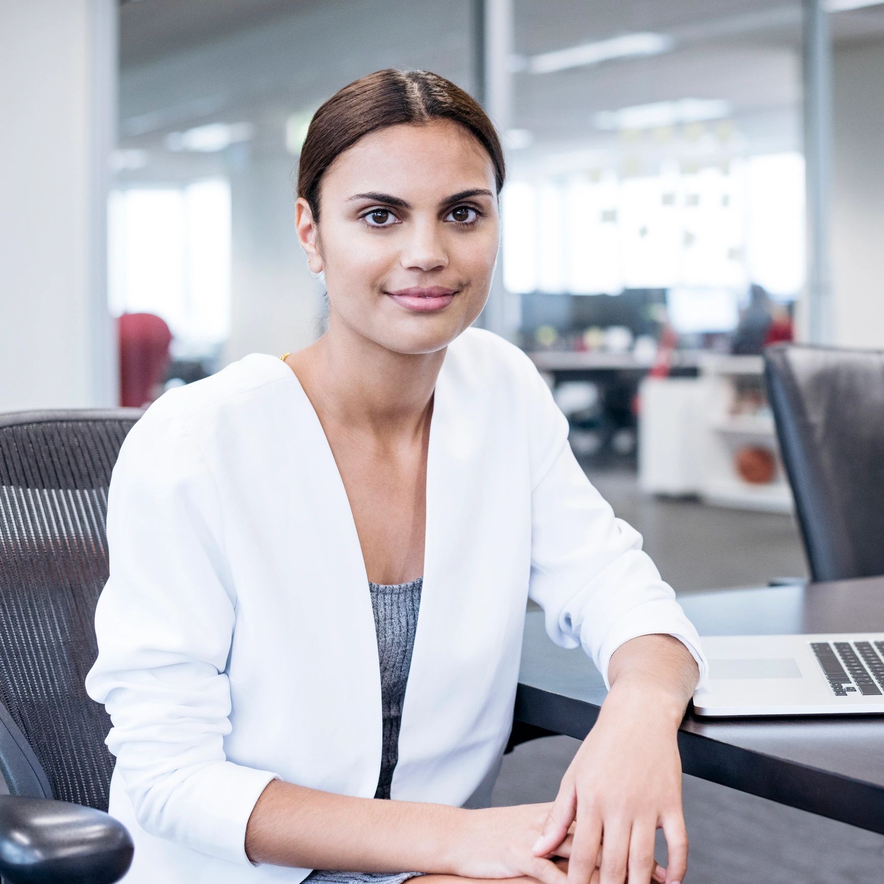 Friendly professional woman at office desk smiling